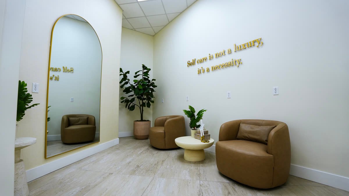 Seating corner with gold lettering: self care is not a luxury, it's a necessity